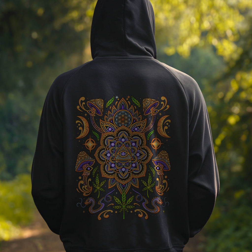 Person wearing a black hoodie with a colorful mandala design in a forest setting
